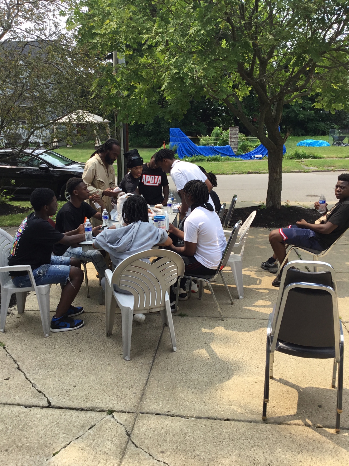 Youth gathered around an outdoor table sharing a meal together